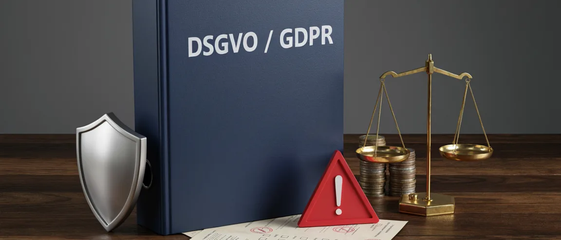 DSGVO/GDPR-Ordner mit Schutzschild, Waage und Warnsymbol auf einem Schreibtisch – externer Datenschutzbeauftragter